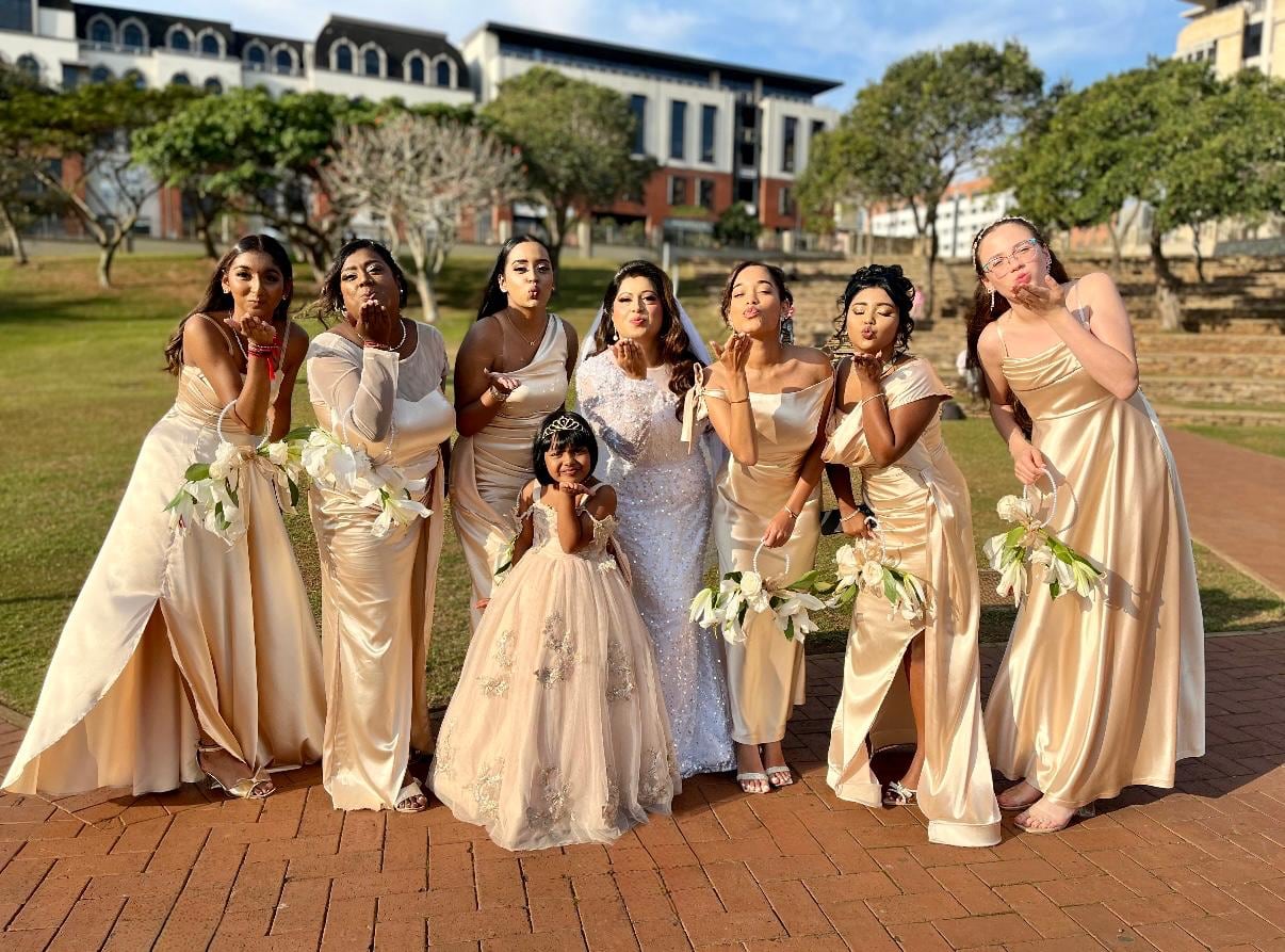 Bridal party in gold gowns holding pastel bouquets