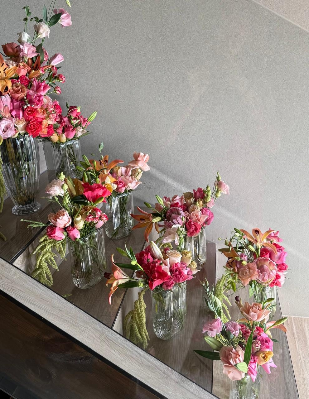 Bud vases of mixed blooms stepped along a staircase