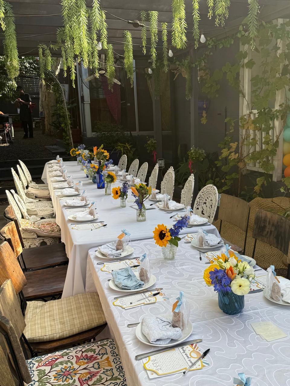 Long banquet table dressed with low floral runners and glassware