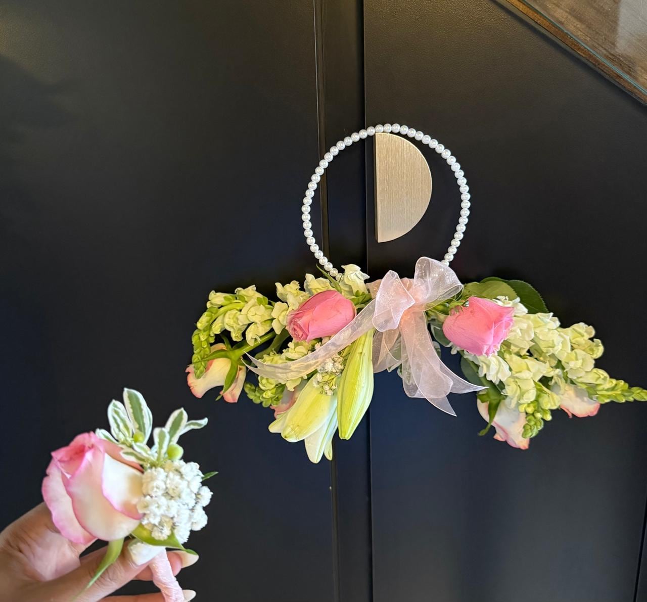 Garland of pale blooms and pearls hung between two gilded discs